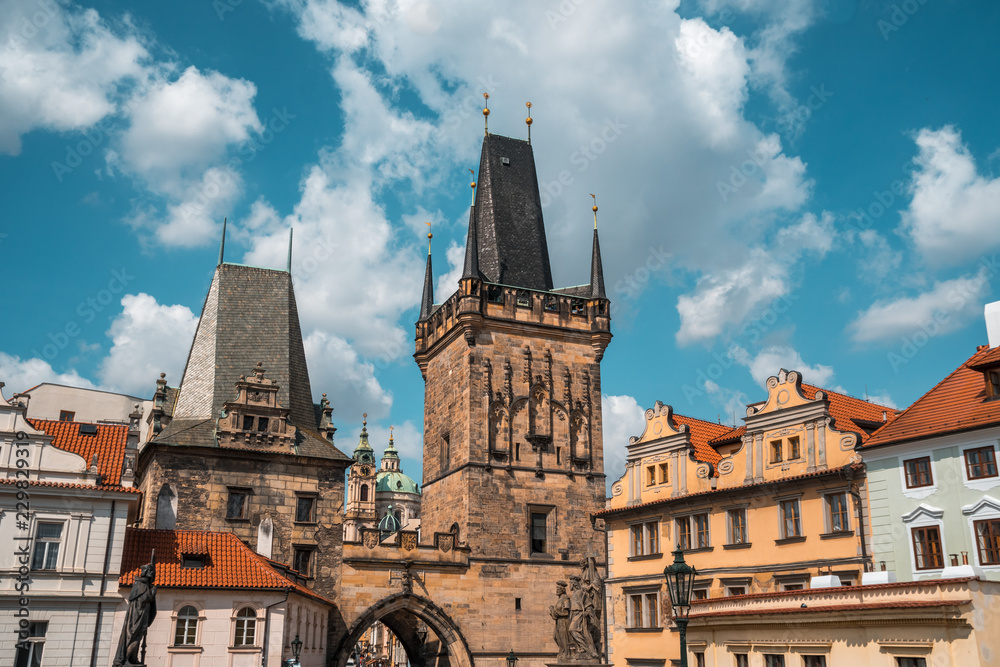 Gothic tower of the charles bridge aganst the blue sky in Prague