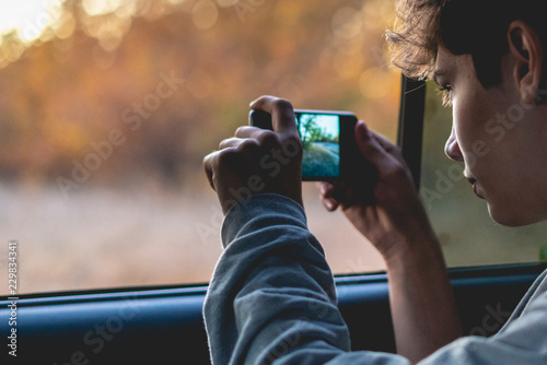 young person doing a photo on a smartphone in national park f