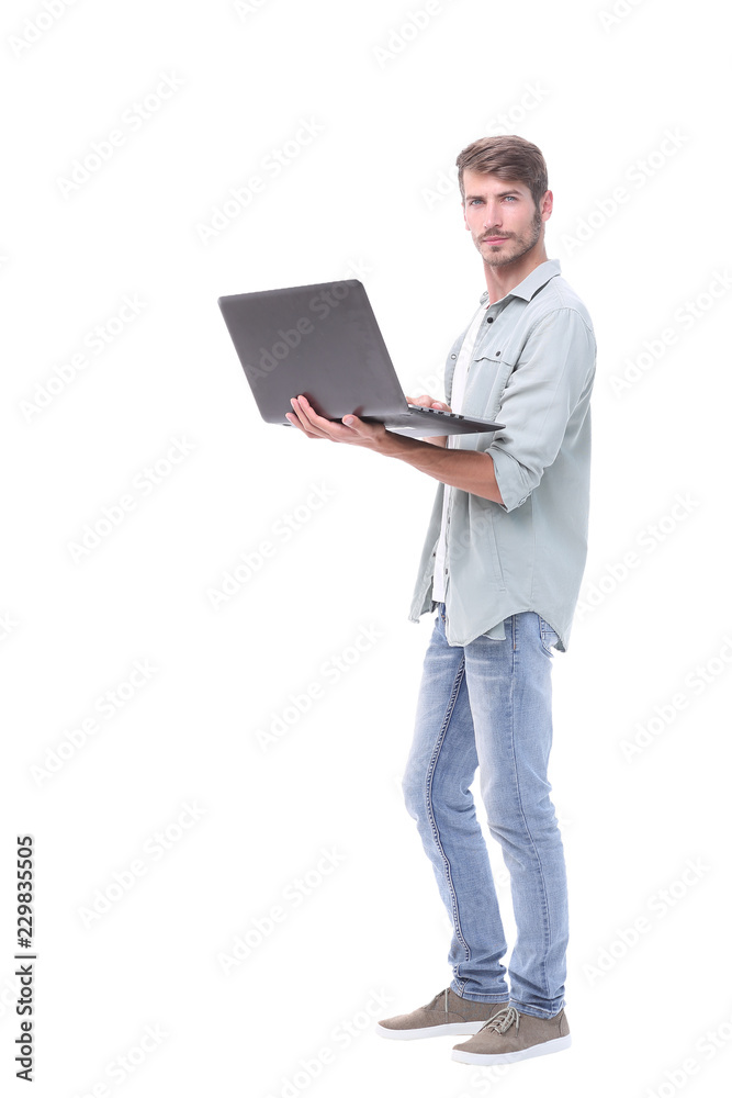 in full growth.successful young man with a laptop in full growth.successful young man with a laptop