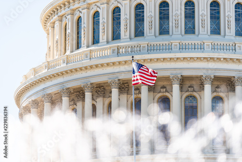 US Congress dome closeup with background of water fountain splashing, American flag waving in Washington DC, USA closeup on Capital capitol hill, columns, pillars, nobody photo