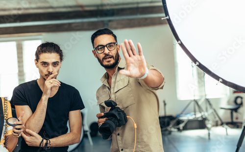 Photographer adjusting the pose of the model during a photo shoo photo