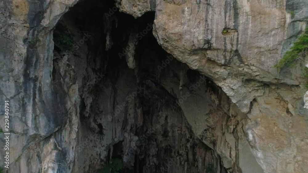 Aerial: Moving backward revealing shot of a massive cave entrance at Mount Senyum in Malaysia Aerial: Moving backward revealing shot of a massive cave entrance at Mount Senyum in Malaysia
