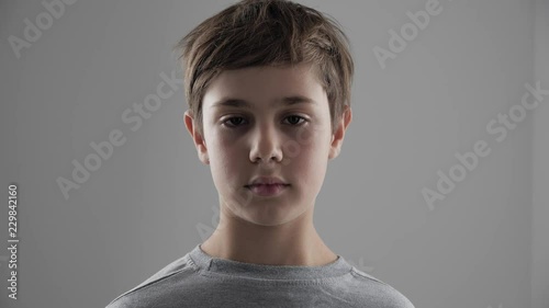 Portrait of cute young 11 - 12 year old boy looking at the camera on white background photo