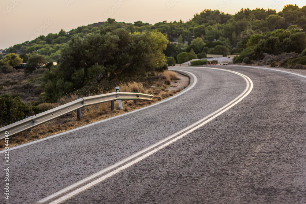 Naklejka premium empty small highway country side road in landmark nature hill environment in evening between sunset 