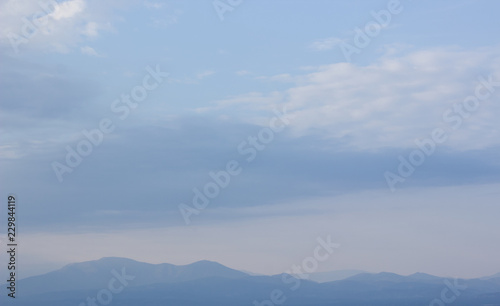 vivid mountain silhouette horizon line scenery nature landscape in evening twilight time and soft blue fog everywhere, copy space wallpaper