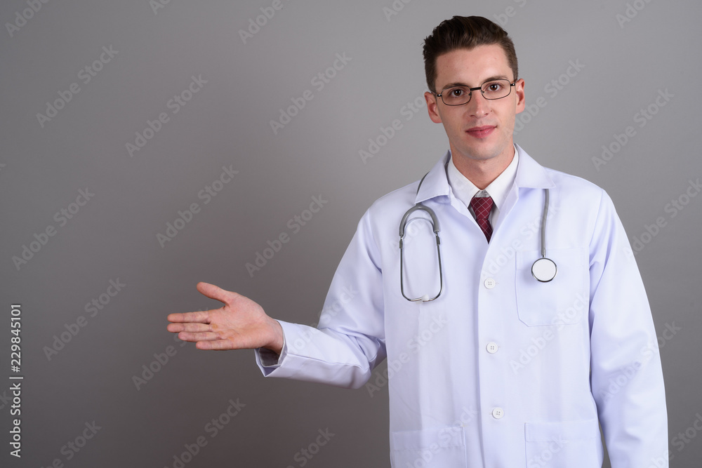 Young handsome man doctor showing copy space Young handsome man doctor showing copy space