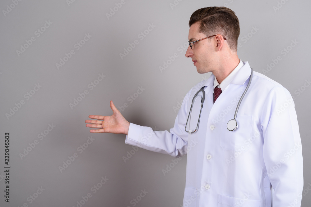 Young handsome man doctor showing copy space Young handsome man doctor showing copy space