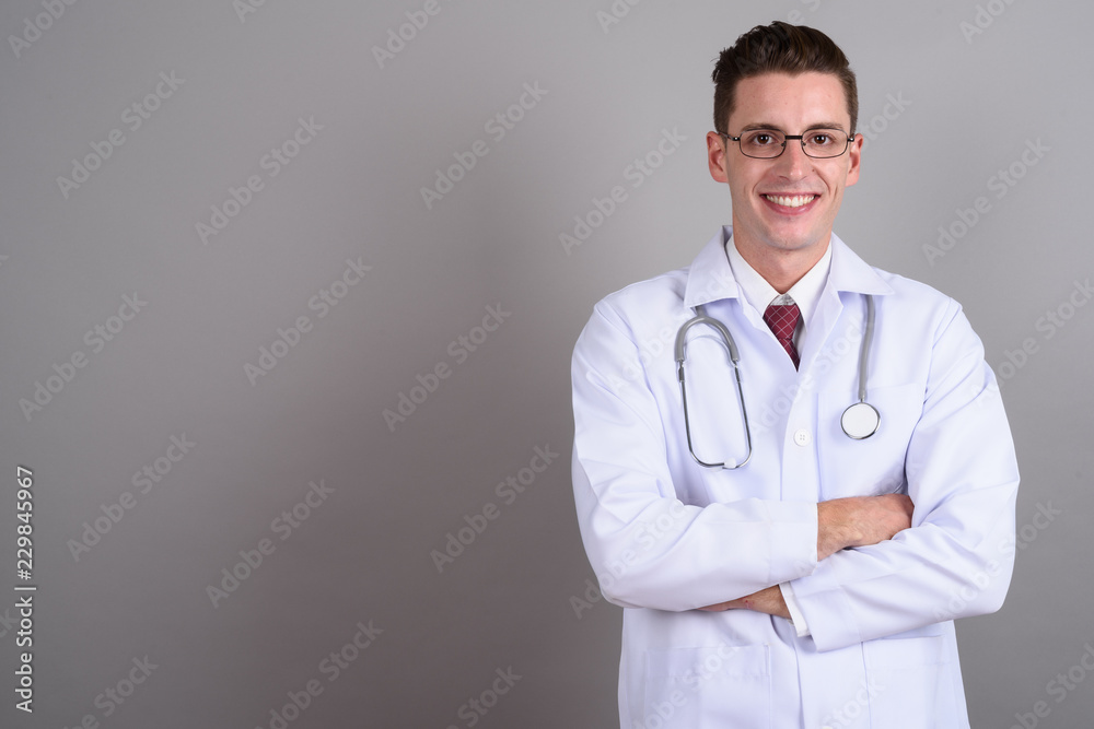 Young handsome man doctor smiling with arms crossed Young handsome man doctor smiling with arms crossed