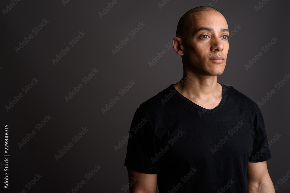 Fototapeta premium Handsome bald man wearing black shirt and thinking