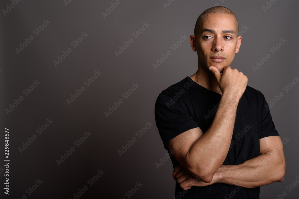 Handsome bald man wearing black shirt and thinking