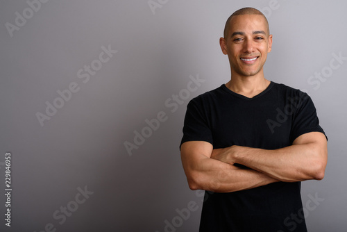 Portrait of handsome bald man smiling with arms crossed