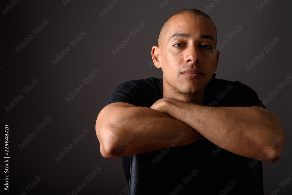 Portrait of handsome bald man sitting on chair Portrait of handsome bald man sitting on chair