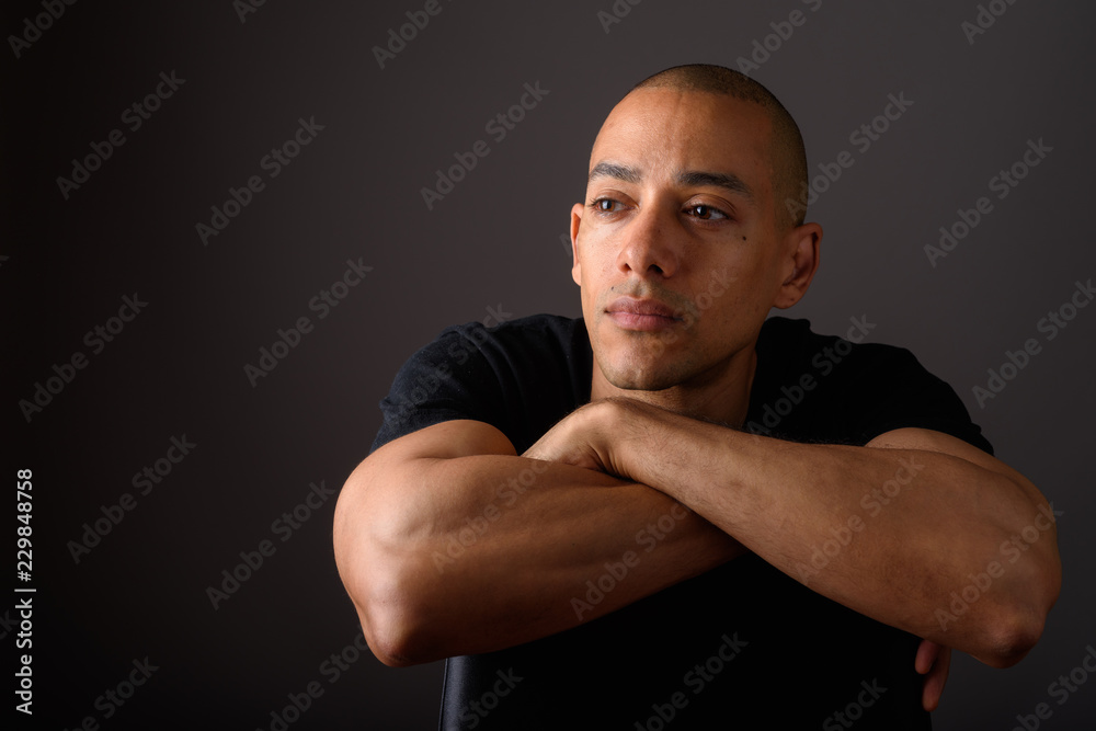 Portrait of handsome bald man sitting on chair while thinking Portrait of handsome bald man sitting on chair while thinking