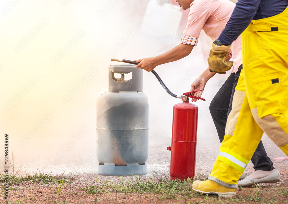 Obraz premium Volunteer using fire extinguisher from hose for fire fighting during basic fire fighting training and fire drill evacuation