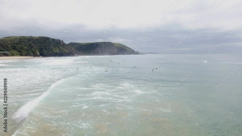 Cinematic flying of surfers surfing along coast of East London South Africa aerial Cinematic flying of surfers surfing along coast of East London South Africa aerial
