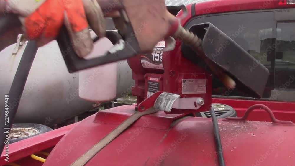 Removing a fuel nozzle from a portable tank to refuel equipment