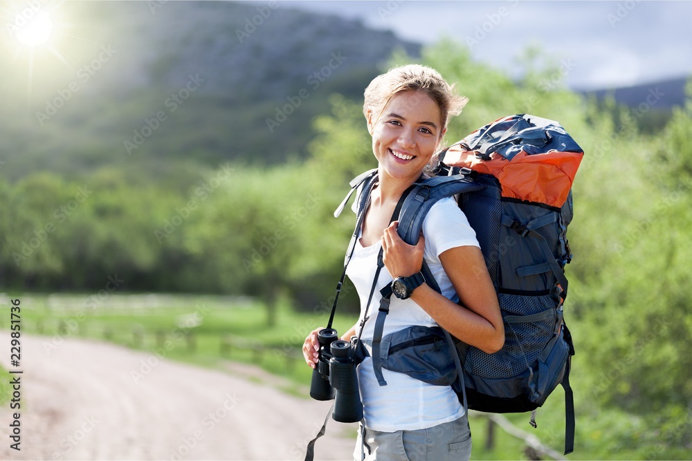Woman with backpack trekking through the mountains