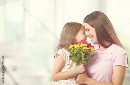 Happy Mother and daughter together with flowers