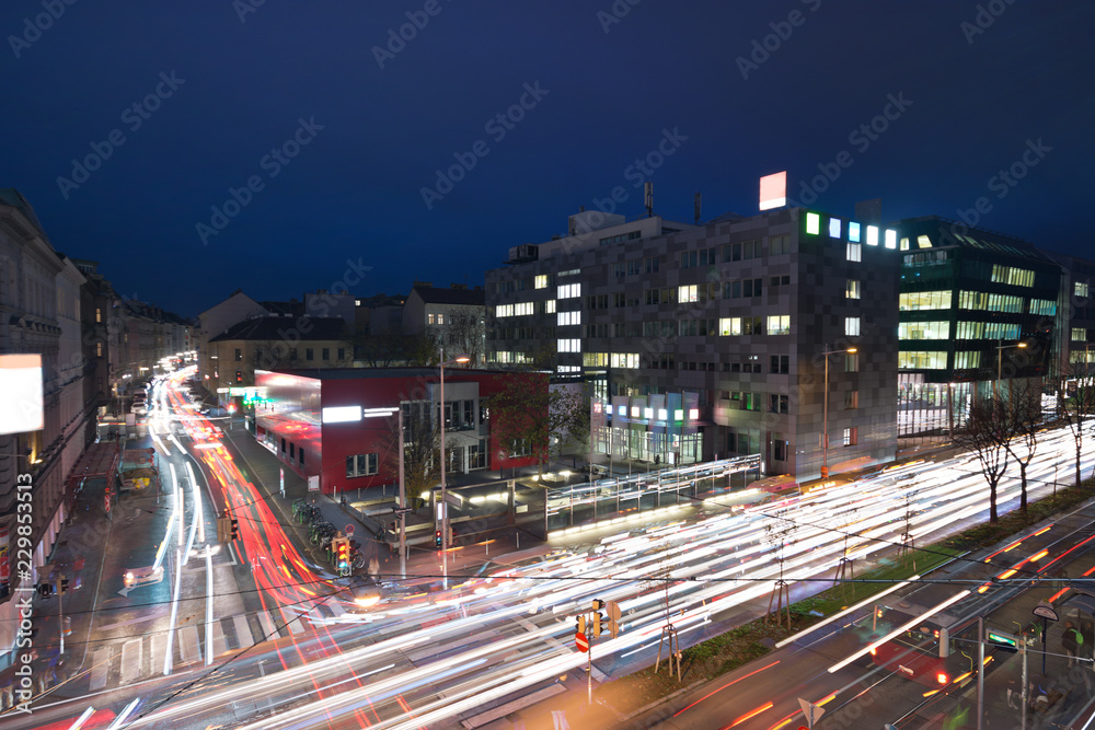 Aerial view of nightly traffic with car light trails on the Waehringer Guertel road intersection with Gentzgasse in Vienna.