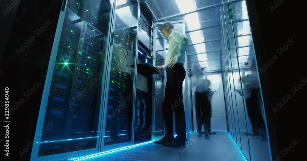 From below view in time lapse of diverse engineers working in data center and leaving room with light going out
