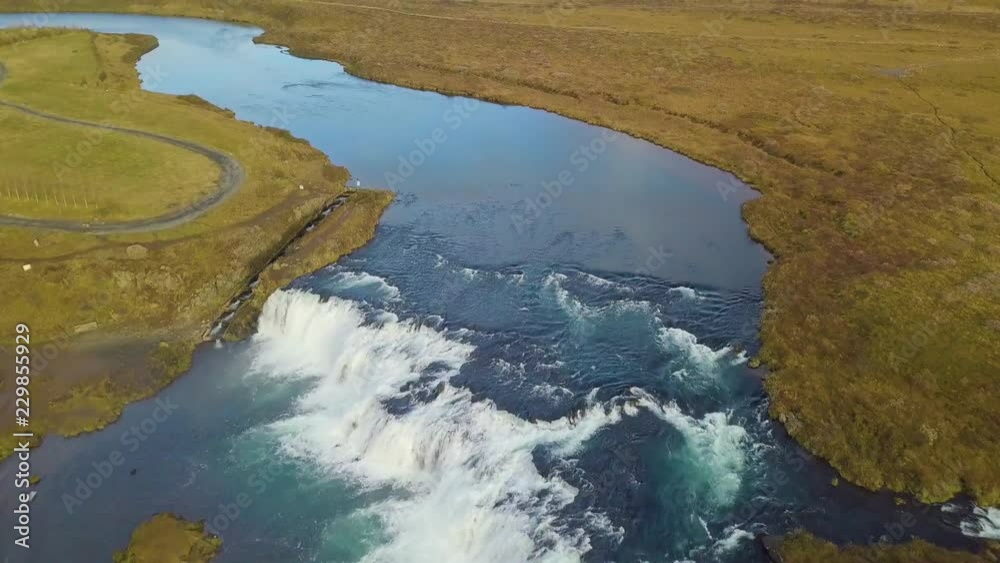 Drone view tilting up from Faxi Waterfall to reveal the Icelandic landscape Drone view tilting up from Faxi Waterfall to reveal the Icelandic landscape