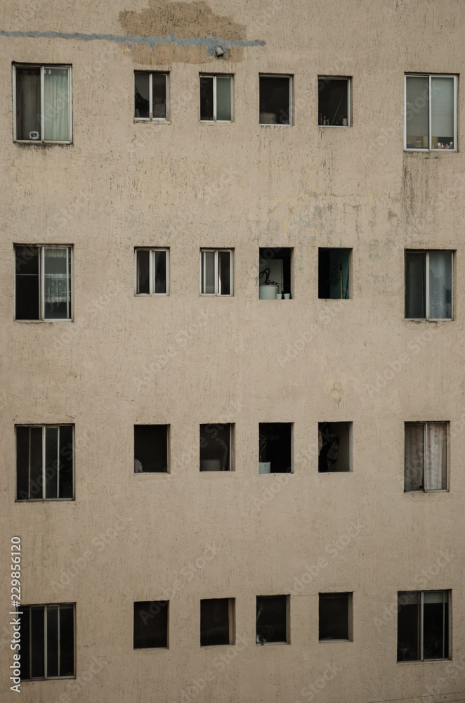 close up to a building, pattern of windows of a gray building