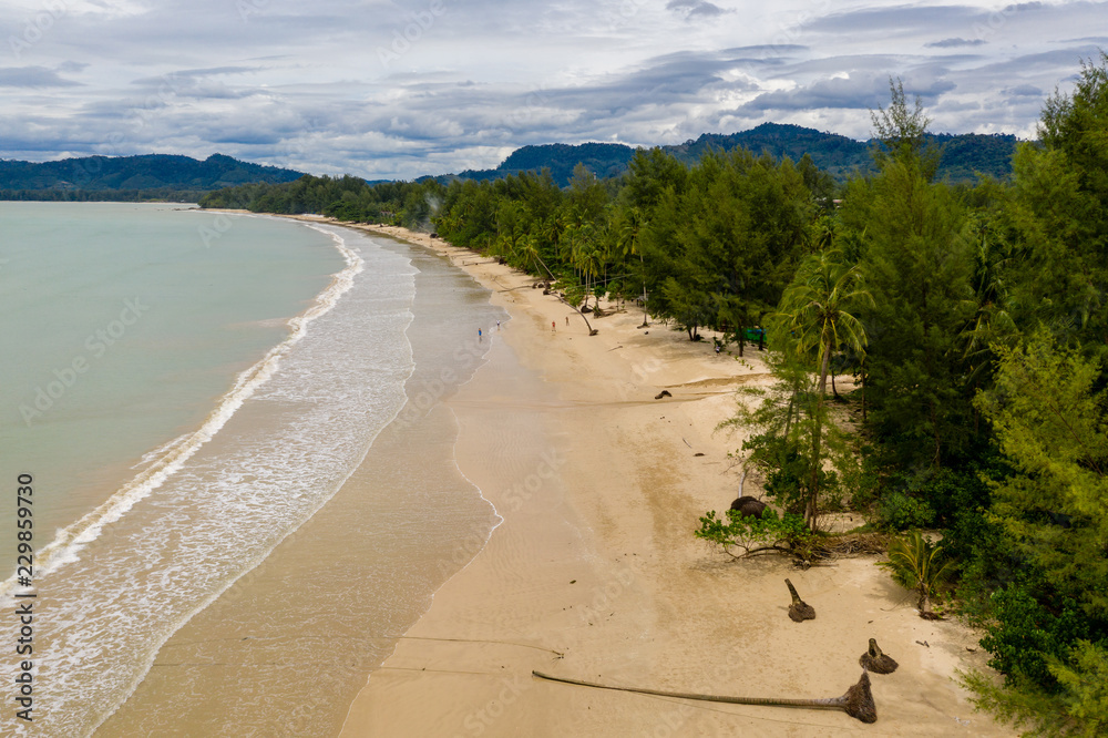 Aerial drone view of a beautiful empty tree lined tropical beach Aerial drone view of a beautiful empty tree lined tropical beach