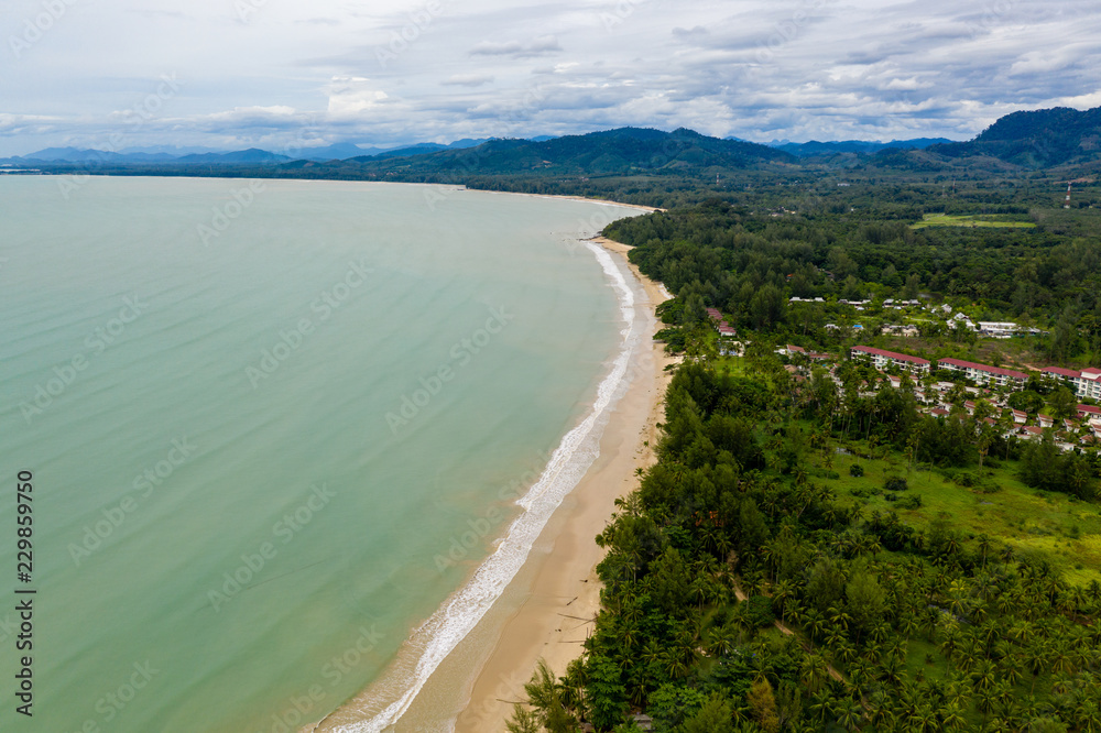 Aerial view of a beautiful, empty tropical sandy beach and palm trees