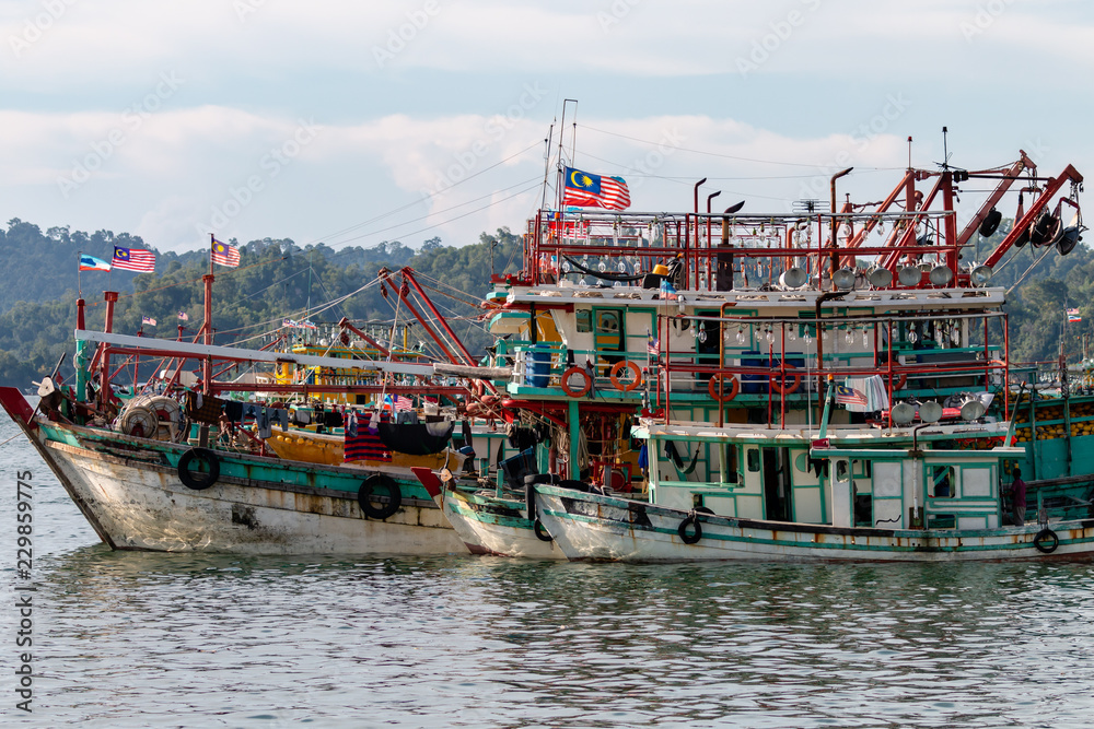 Fototapeta premium A fleet of fishing boats moored at port in Asia