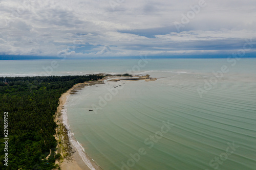 Aerial view of a beautiful  empty tropical sandy beach and palm trees