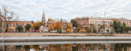 Fotografie View of the city embankment, old houses and church of the ancient city of Russia