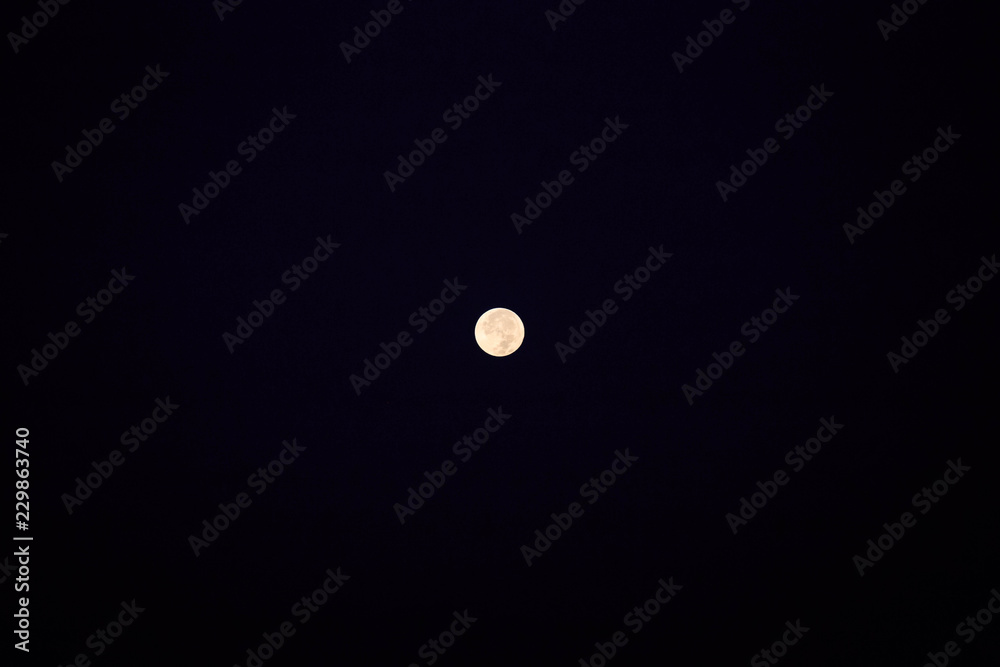 Bright full moon shines against dark black background Bright full moon shines against dark black background
