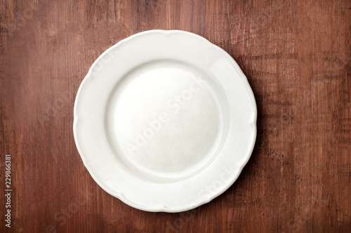 White plate, shot from above on a dark rustic wooden background with a place for text