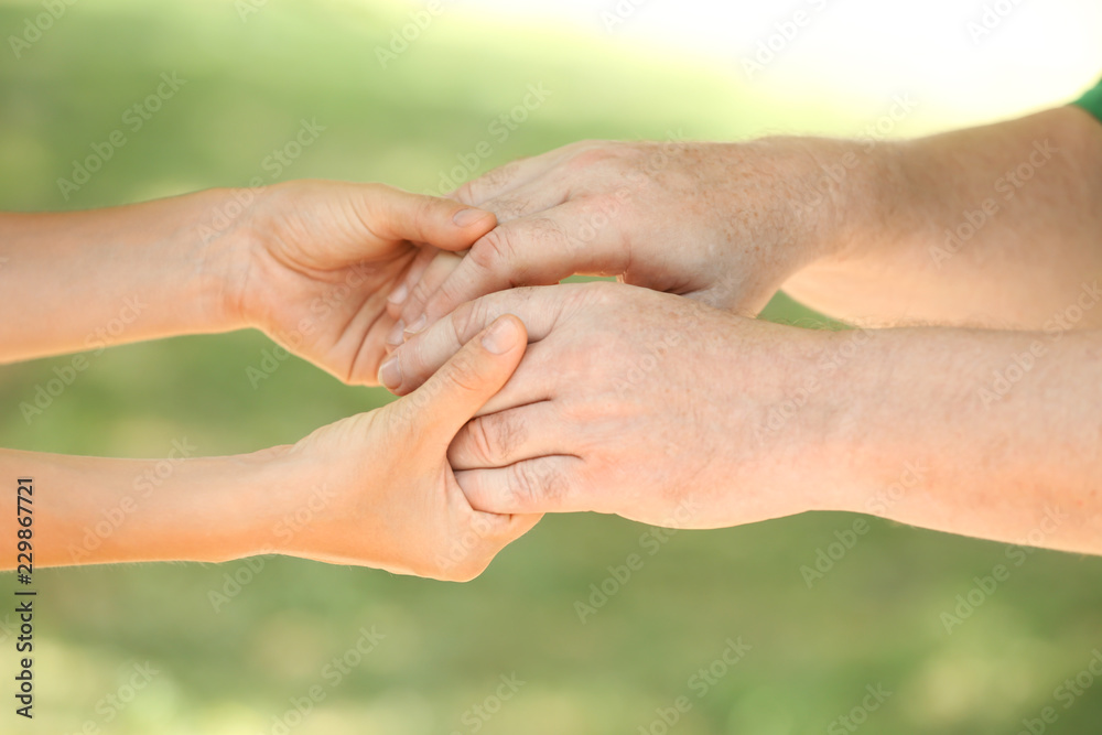 Helping hands on blurred background, closeup. Elderly care concept Helping hands on blurred background, closeup. Elderly care concept