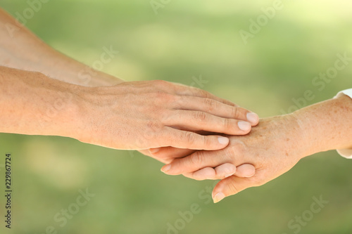 Helping hands on blurred background, closeup. Elderly care concept © New Africa