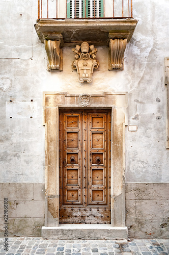 Coat of arms of Pope Clement XI above a door in the city of Sassocorvaro in Italy. Clement XI was a patron of the arts and of science. He was also a great benefactor of the Vatican Library photo