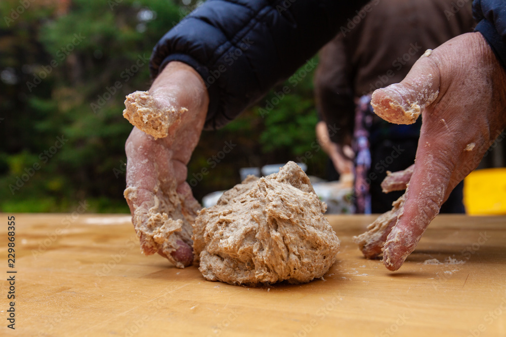 The beginning of the kneading process to make bread, as part of an outdoors workshop - Pictures taken during a bread and pizza making workshop with many people The beginning of the kneading process to make bread, as part of an outdoors workshop - Pictures taken during a bread and pizza making workshop with many people