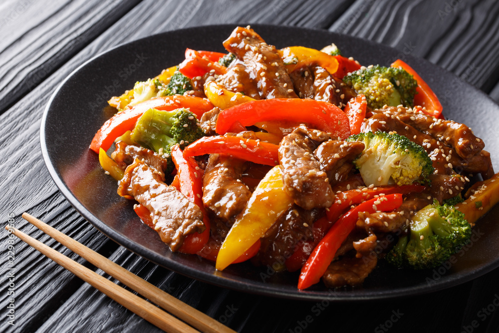 Wunschmotiv: Spicy teriyaki beef with red and yellow bell peppers, broccoli and sesame seeds close-u