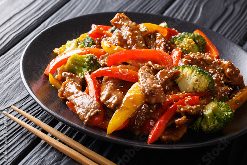 Spicy teriyaki beef with red and yellow bell peppers, broccoli and sesame seeds close-up. Asian style. horizontal