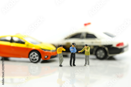 Miniature people : Police officer emergency service car driving street.