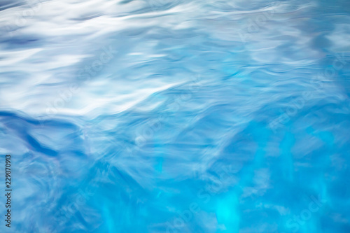 The smooth natural blue water background with bokeh abstract on the sea or ocean,vintage and soft colored blur.