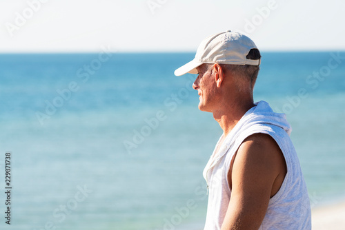 Happy adult man relaxes on the beach on a sunny day