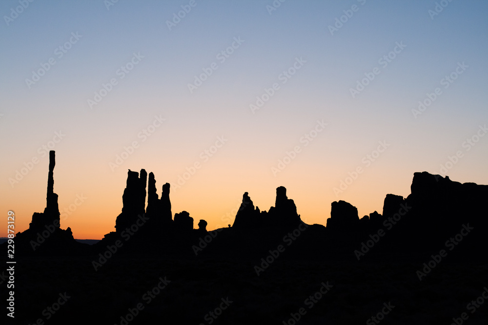 totem pole in monument valley at sunset