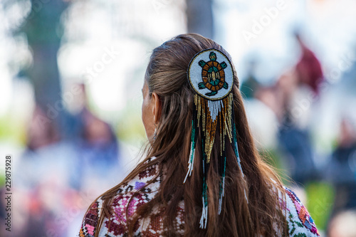 Canvas-taulu Woman is wearing a large turtle beaded hair pin and colorful native clothing whi