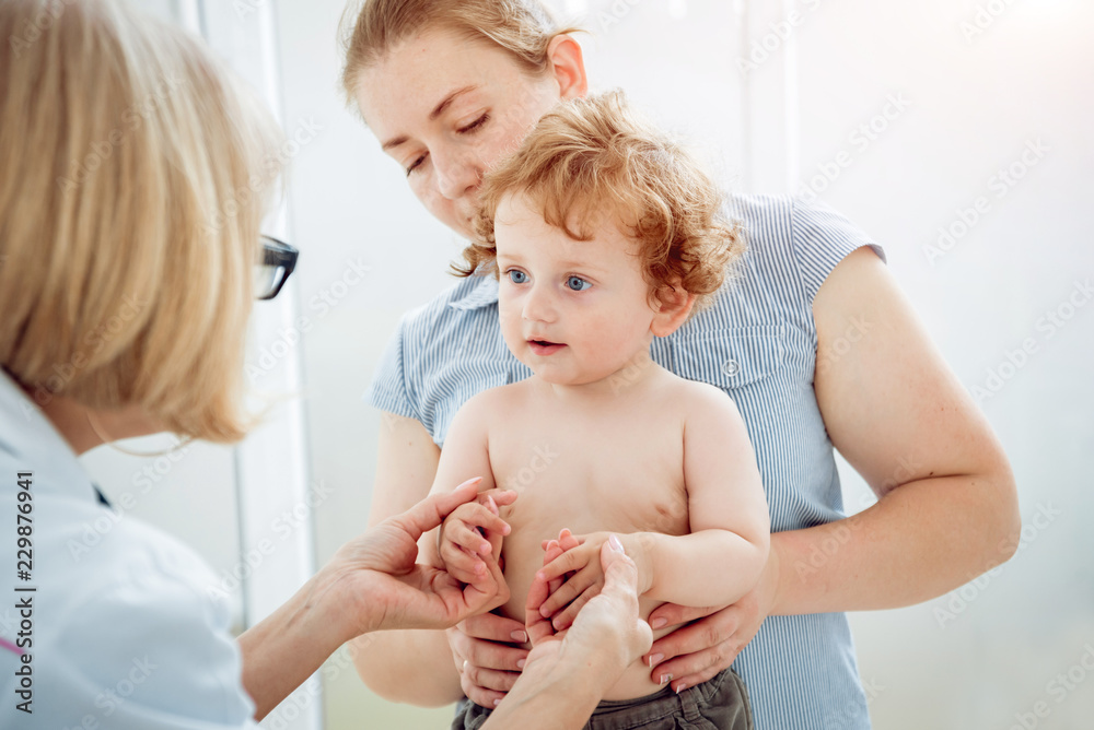 Friendly doctor pediatrician with patient child at clinic Friendly doctor pediatrician with patient child at clinic