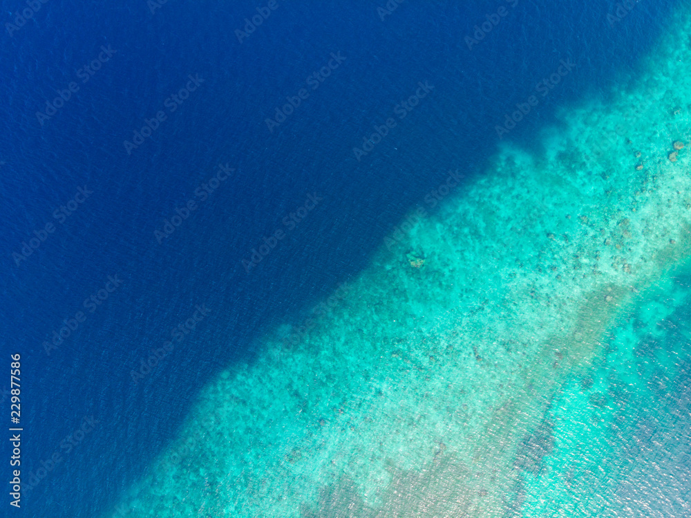 Aerial top down view coral reef tropical caribbean sea, turquoise blue water. Indonesia Moluccas archipelago, Kei Islands, Banda Sea. Top travel destination, best diving snorkeling.