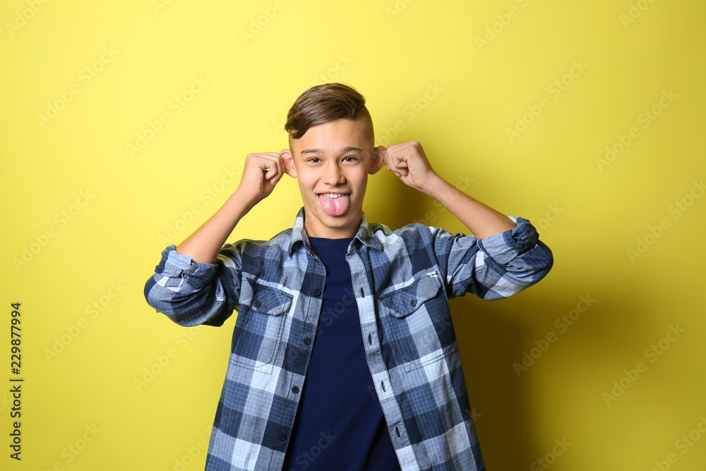 Funny teenage boy on color background