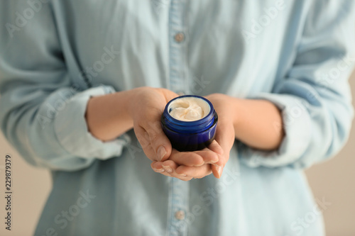 Woman holding jar of body cream, closeup