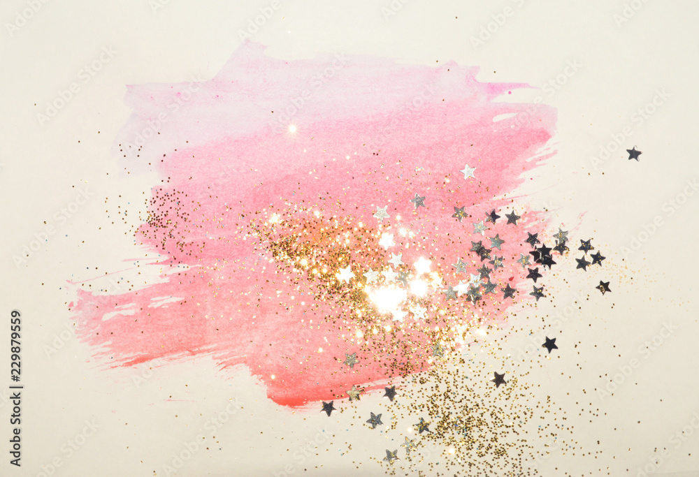 Golden glitter and glittering stars on abstract pink watercolor splash in vintage nostalgic colors.
