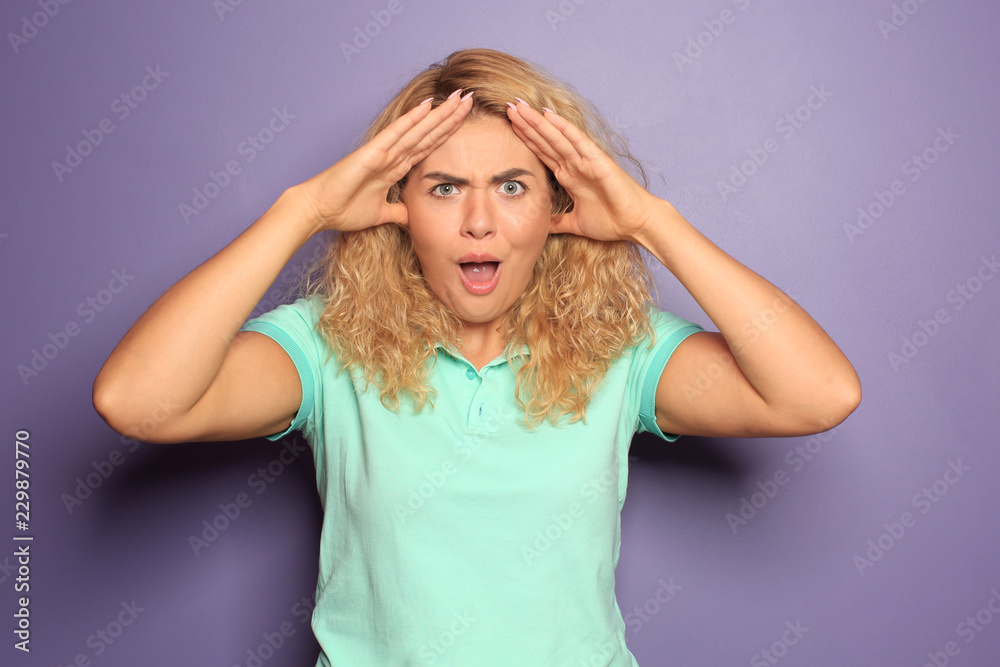 Portrait of irritated young woman on color background
